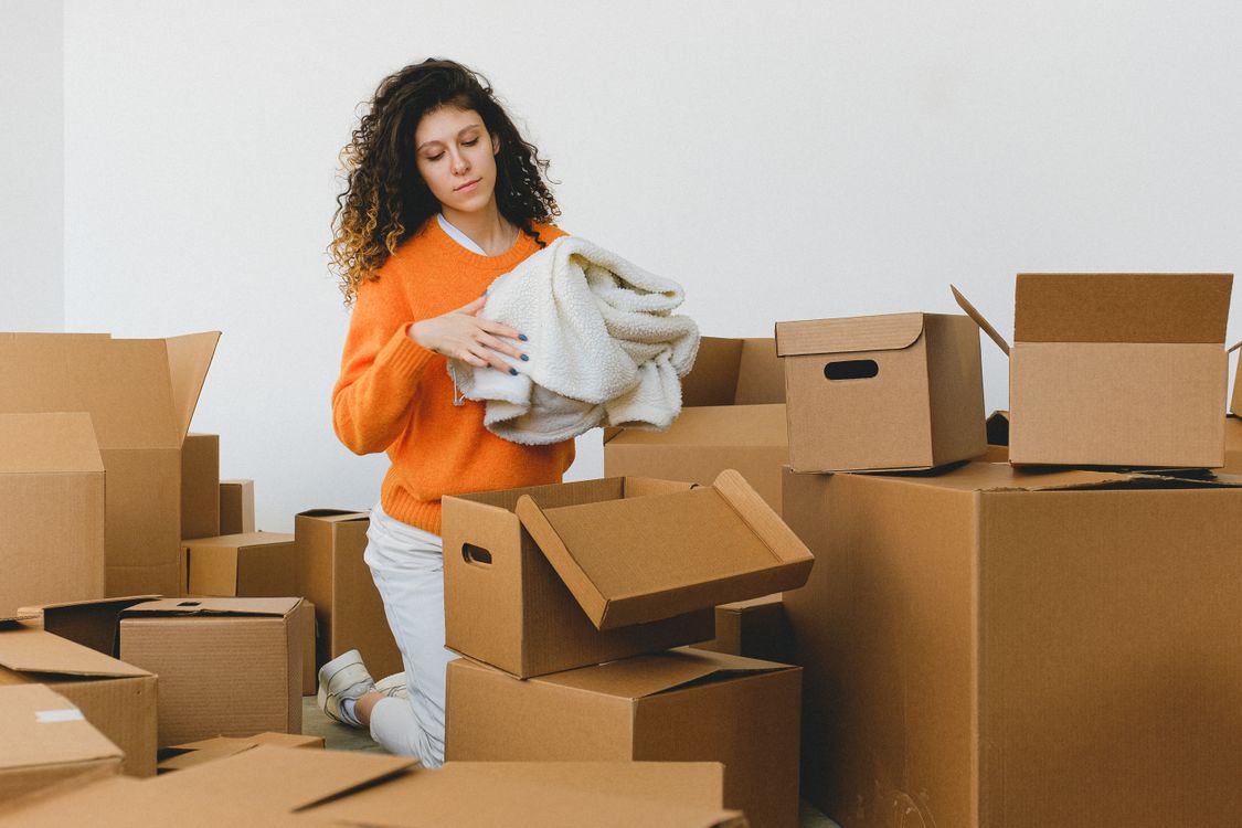 Jeune femme emballant ses affaires dans des cartons de déménagement