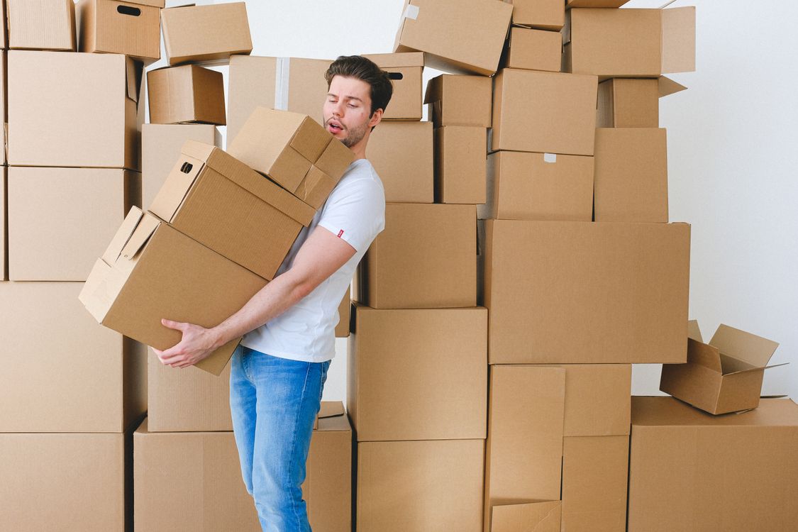 Jeune homme portant des cartons pendant un déménagement