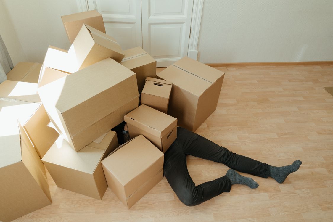Cartons de déménagement empilés sur un plancher en bois