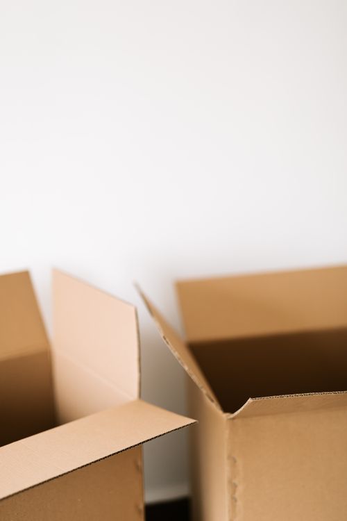 Cartons de déménagement empilés contre un mur, prêts pour le stockage en garde-meuble