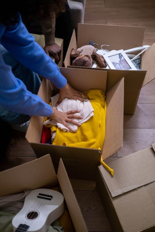 Personne emballant ses affaires dans un carton de déménagement