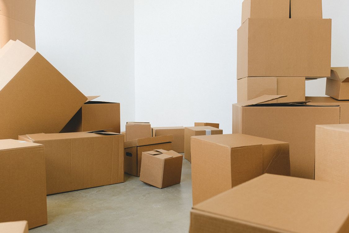 Pile de cartons éparpillés sur le sol lors d'un déménagement